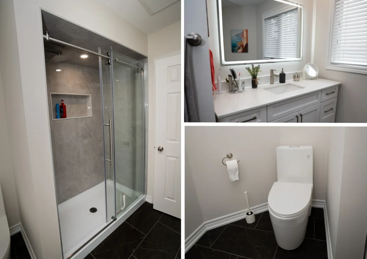 After: a grey sliding-door shower with a recessed niche, a white shaker vanity with a backlit mirror and a new toilet on dark porcelain tile