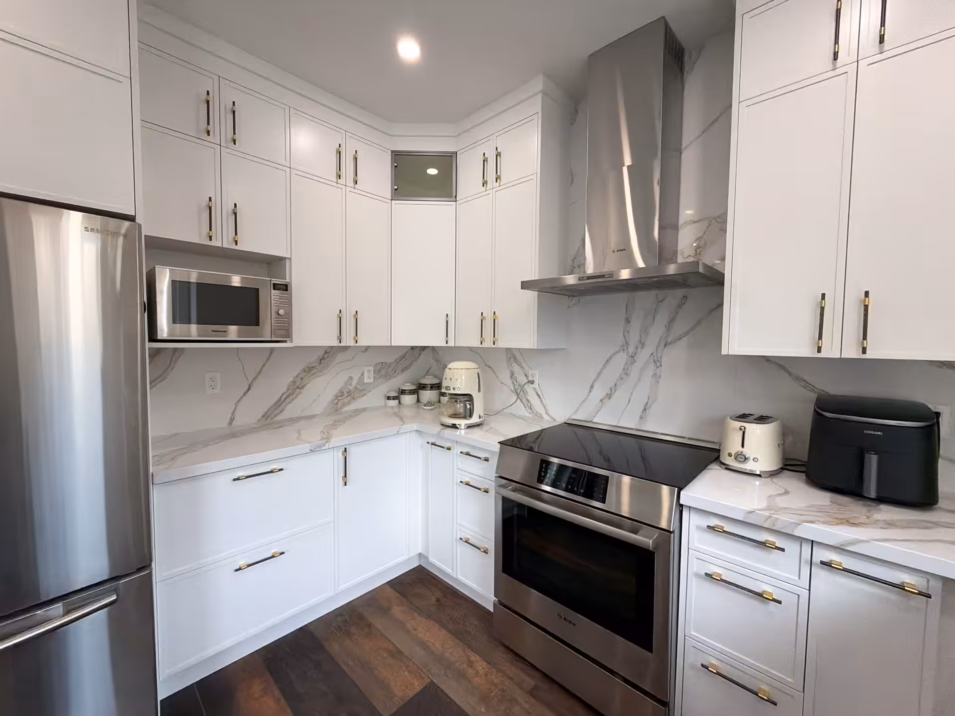 White kitchen with stainless range and custom hood