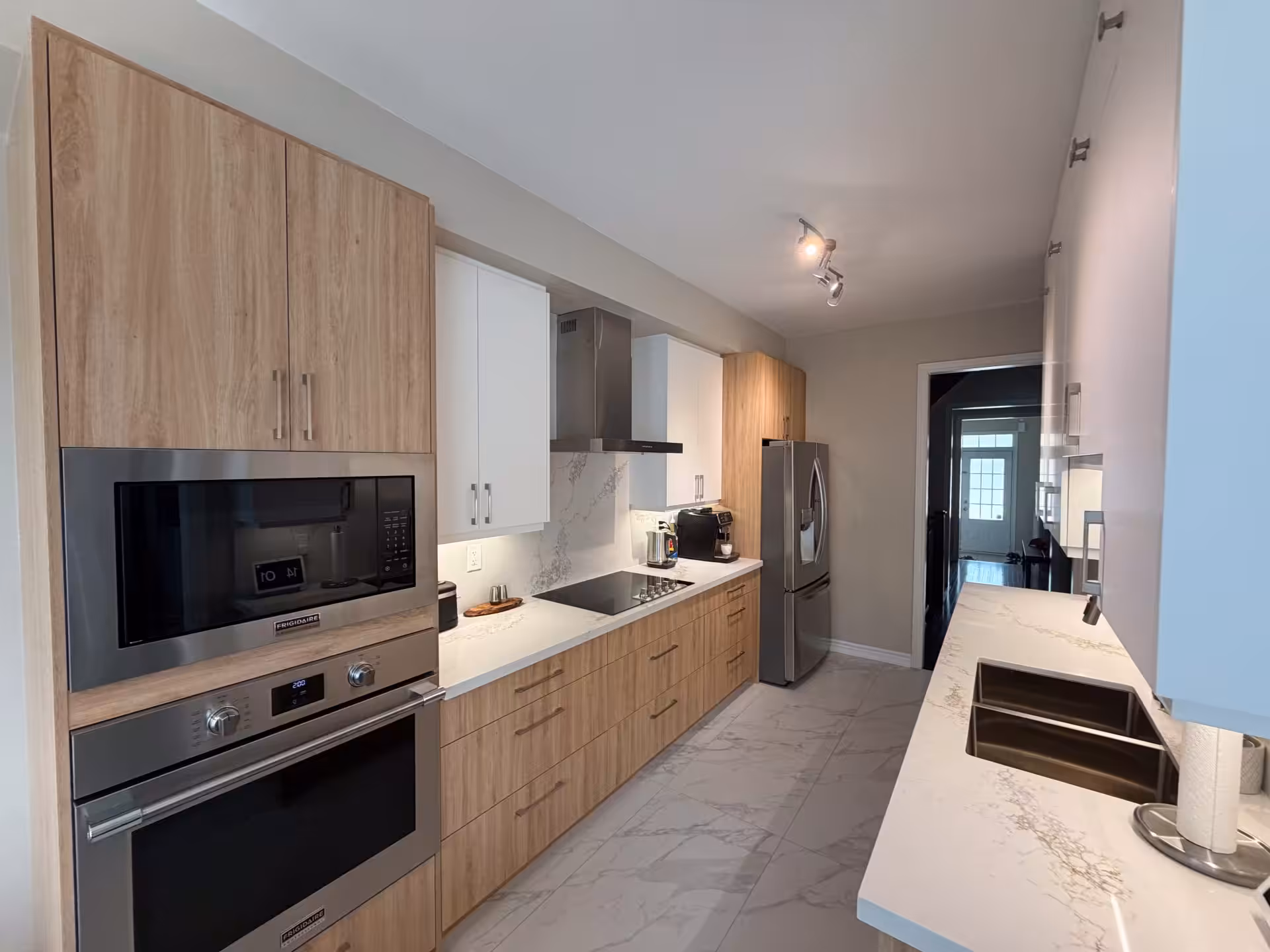 Kitchen with built-in wall oven and light wood cabinetry