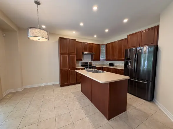 Dated cherry-brown kitchen with a tiled floor and a dark island