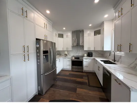 White kitchen with stainless appliances over dark hardwood