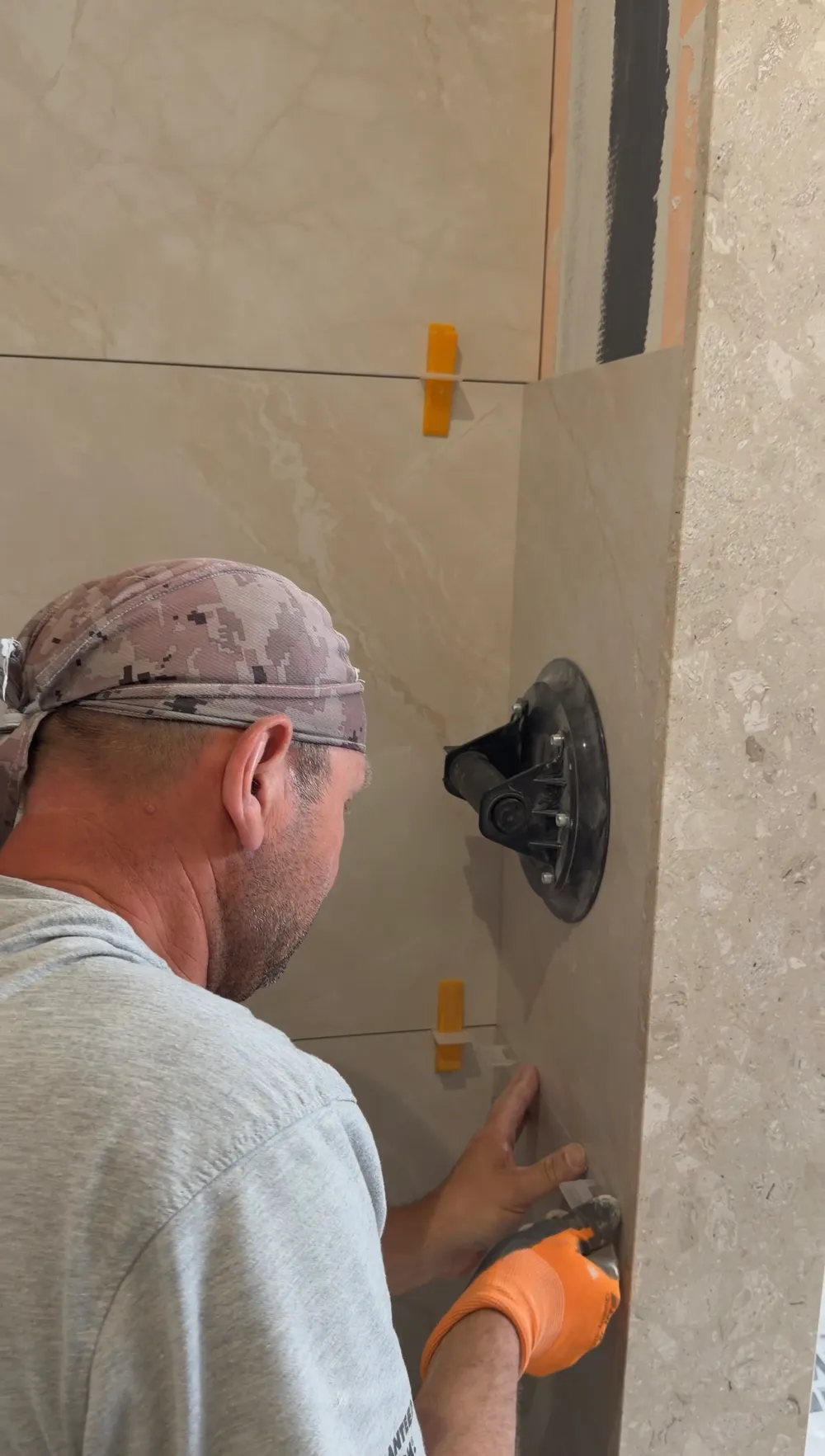 Setting a wall tile with a suction cup, the spacers in