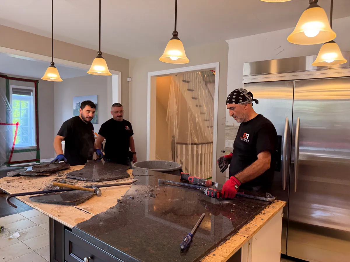 Two of our crew lifting out an old countertop on demolition day
