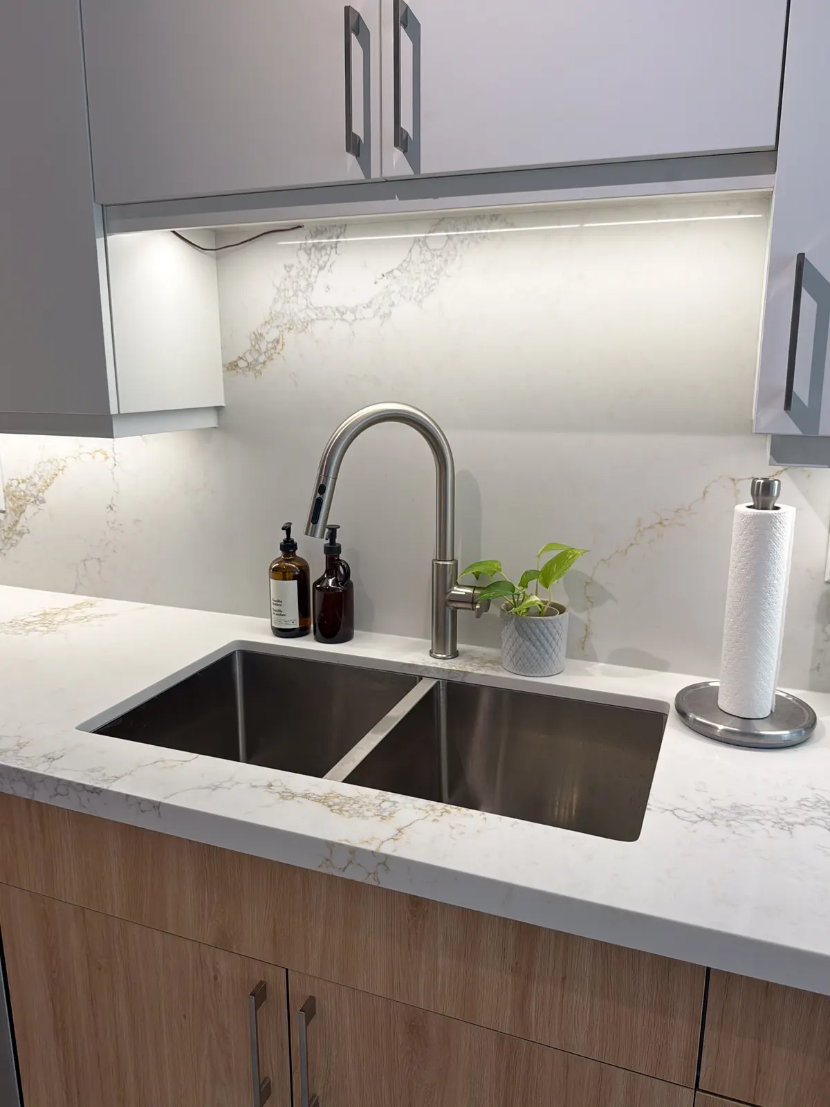 Close-up of an undermount sink against a full-height marble backsplash